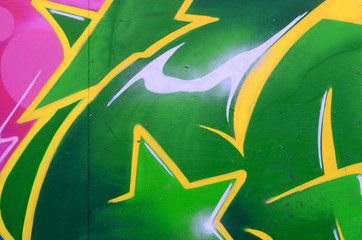 Fragment of graffiti drawings. The old wall decorated with paint stains in the style of street art culture. Colored background texture