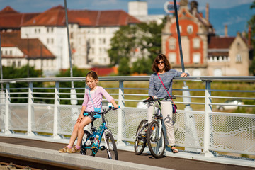 Mother with daugter running by bicycles in Strasbourg - obrazy, fototapety, plakaty