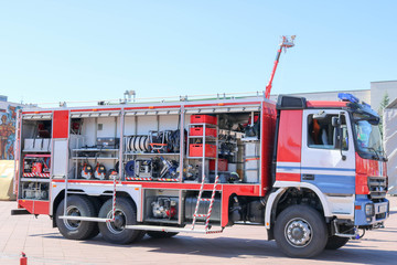 Large special red with blue fire car, engine to rescue people with open sides and extinguishing equipment, fire pump, blowing agent, tool, water sleeves, hoses, baloons, equipmen