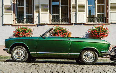 Beautiful retro green car on the street, sunny day