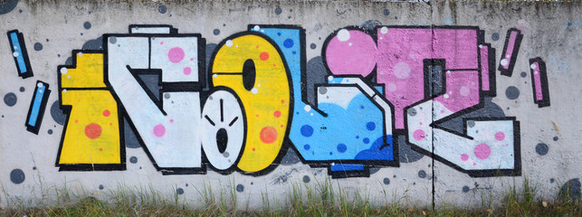 Full and acomplished graffiti artwork. The old wall decorated with paint stains in the style of street art culture. Colored background texture
