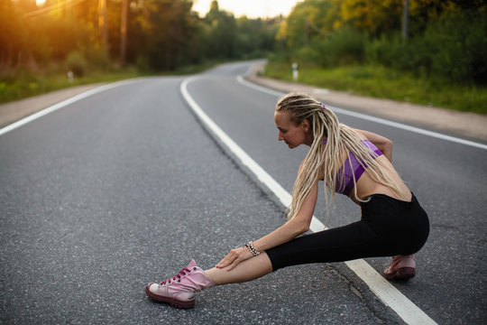 Woman runner warming up on the road before Jogging.