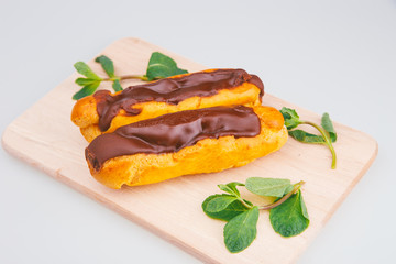Eclairs on plate on a table on light background