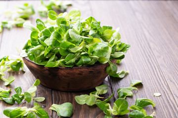 Fresh Juicy Green Corn Salad in wooden bowl, wooden background