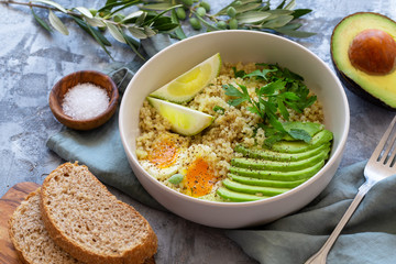 Healthy bowl with quinoa, eggs, avocado, lime and parsley. Food and health.