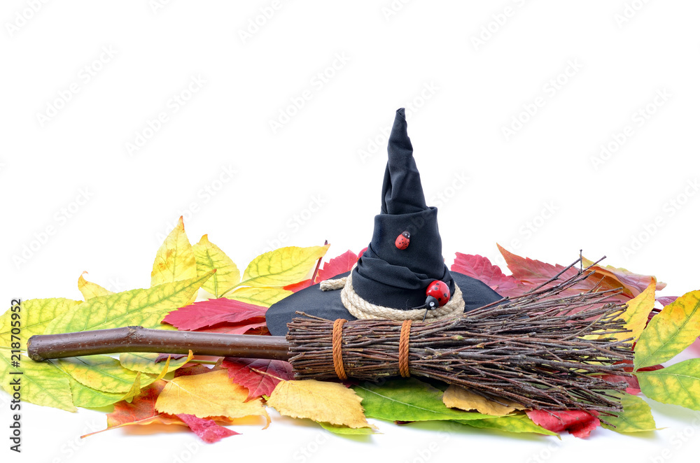 Wall mural A witch's hat and a broom on the autumn leaves. - Wall murals
