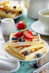 Traditional belgian waffles with fresh berries on white plate