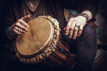 Ethnic percussion musical instrument jembe and male hands