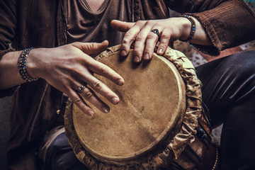 Ethnic percussion musical instrument jembe and male hands - obrazy, fototapety, plakaty