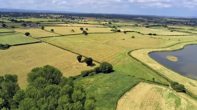 Aerial view, pan move. Drone panorama of plains and small ponds hidden between fields