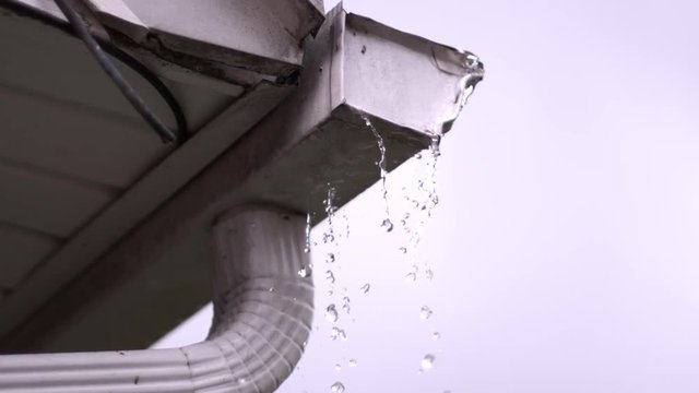 Water overflowing from rain gutter in slow motion