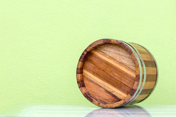 Bottom of classic wooden barrel with classic green wall.