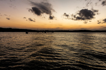 Beautiful sunset on the lake. The sky is painted orange and the water turns silver.