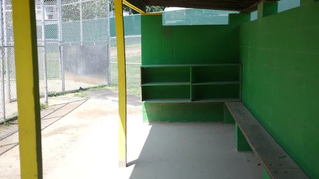 Camera pans across little league baseball empty dugout