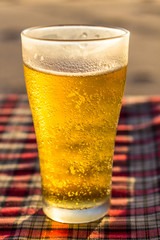 Glass of cold beer on table