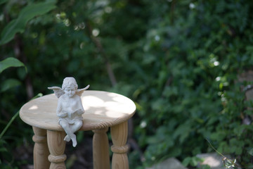 庭で本を読む天使