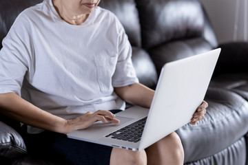 Elderly woman using her computer in home and using laptop