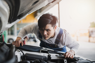 Young Asian machine technicians are analyzing symptoms of broken car at service center repair