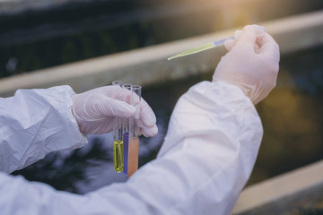 Scientists hands experimenting with water quality at wastewater treatment system. select focus