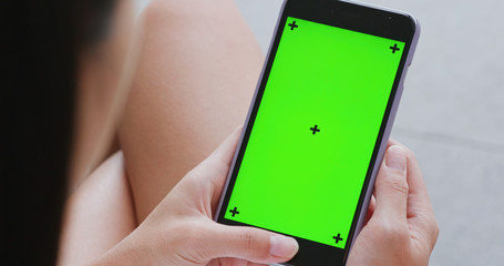 Woman holding mobile phone with chroma key