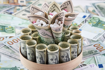 White and pink pills in american dollars banknote on euro banknotes