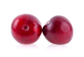 red cherry plum with green leaves isolated on white background