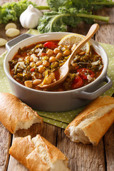 stew of chickpeas, feces, tomatoes, garlic and potatoes with parmesan cheese close-up in a bowl on the table. vertical