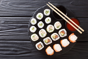 Set Japanese rolls assortment maki, uramaki, hosomaki are served on a stone board. horizontal top view