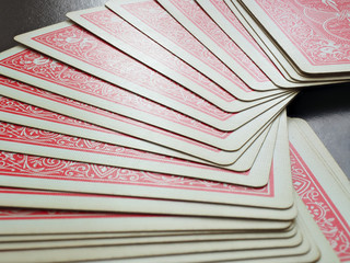 Red poker cards are laid out on the black table. Close up.
