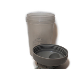 A shaker without a lid that lies next to it, on a white background
