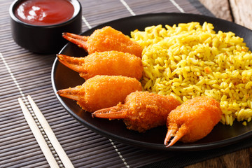Freshly prepared crab claws in deep fried with a side dish of rice and tomato sauce close-up. horizontal