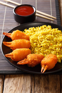 Chinese fast food crab claws in breadcrumbs surimi with spicy yellow rice close-up on a plate. vertical