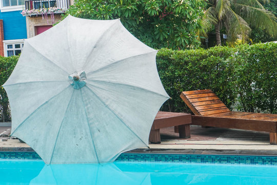 Beach Umbrella With Wooden Seat At Pool Side In Hotel For Holidays