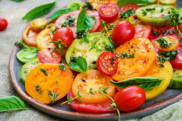Colored tomato salad with onion and basil. Vegan food.