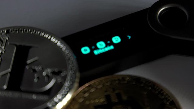 Crypto Currencies Cold hardware wallet lying with golden bitcoin coins. White background, Closeup,