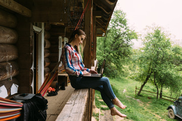 Girl sitting on the railing and looking at the laptop