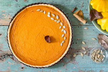 Traditional American pumpkin pie for Thanksgiving Day or Halloween on a wooden background. Rustic style.