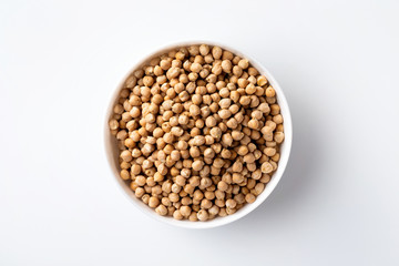 Closeup top view bowl of uncooked chickpeas isolated at white background.