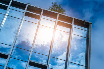 closeup of glass wall of modern building against blue sky
