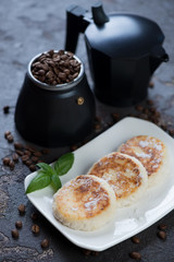 White plate with cottage cheese pancakes and moka coffeemaker in the background, vertical shot, selective focus