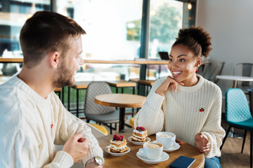 Breakfast with boyfriend. Smiling woman having breakfast with her handsome boyfriend having latte and dessert