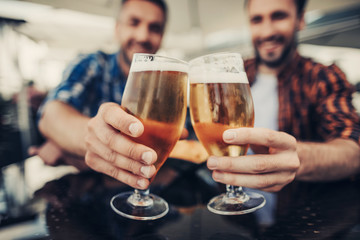 Great celebration. Close up of man arms holding alcohol drinks