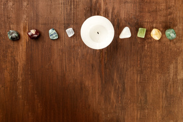 An overhead photo of gemstones with a candle, healing stones