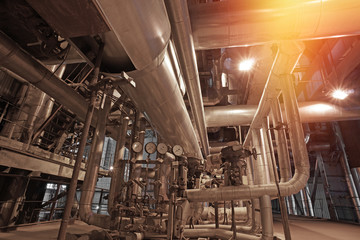 Equipment, cables and piping as found inside of a modern industrial power plant. Industrial zone, Steel pipelines, valves, cables and walkways