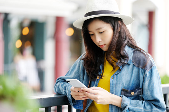 Young asian woman using smart phone in city outdoors background, people on phone, lifestyle