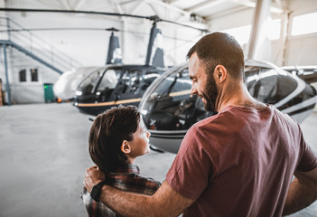Side view optimistic kid communicating with beaming bearded dad while standing opposite...