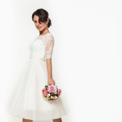 elegant bride on a light background. Beautiful wedding bouquet in a bride hands. free space for...