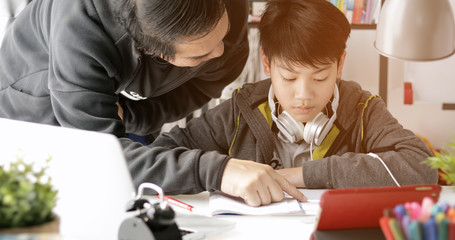 Asian Father and son doing homework at home.