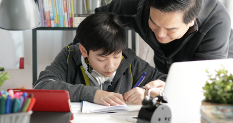 Fototapeta na wymiar Asian Father and son doing homework at home.