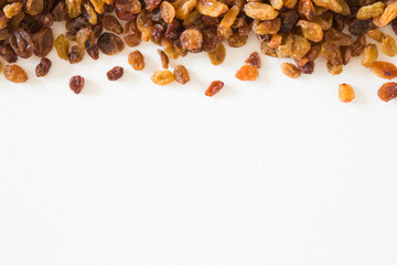Different, colorful raisins on the white background. Dried grapes. Healthy, sweet food. Empty place for text or logo.